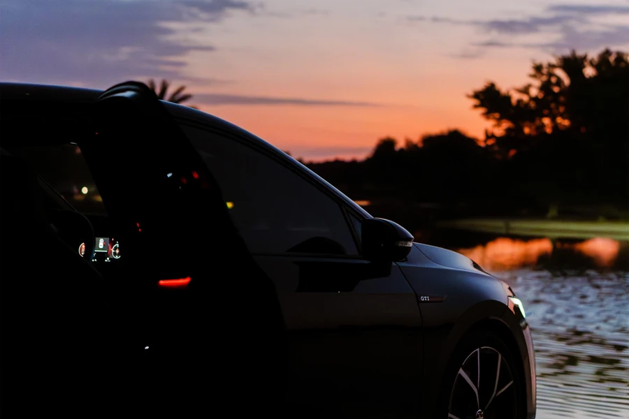 Car beside the water at sunset